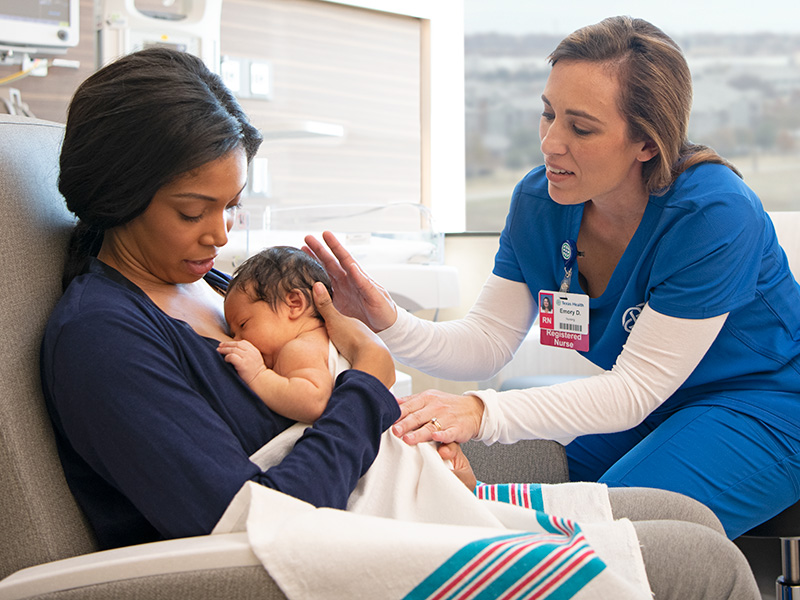 Mom breastfeeding with nurse