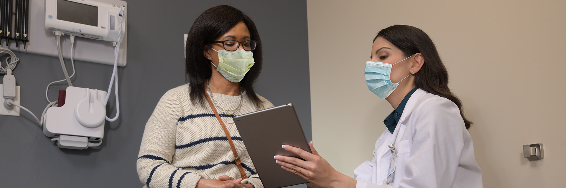 Woman reviewing information on tablet with provider