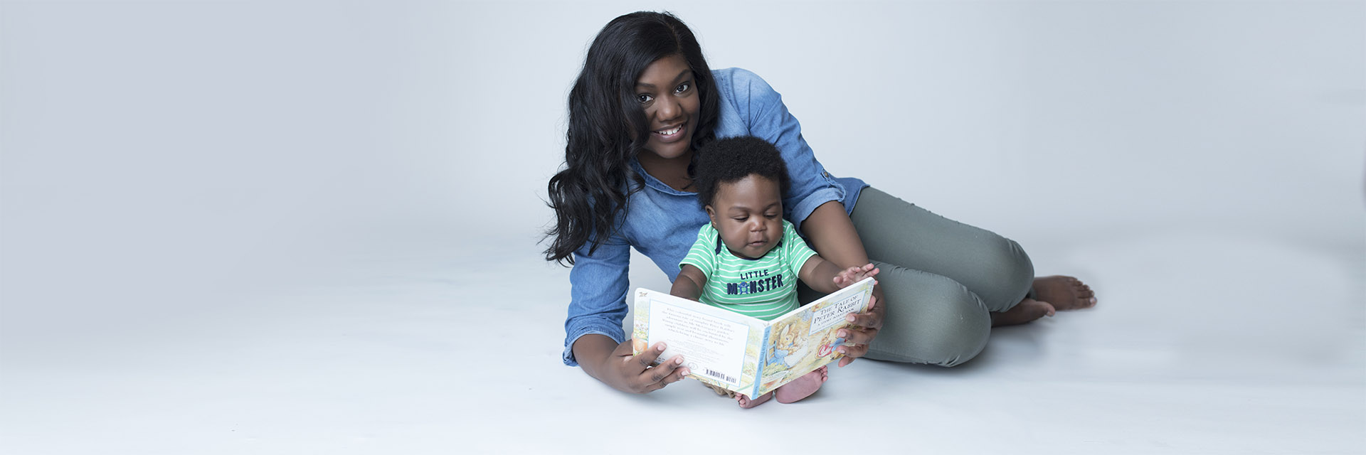 Mom and Baby on Floor Holding a Book