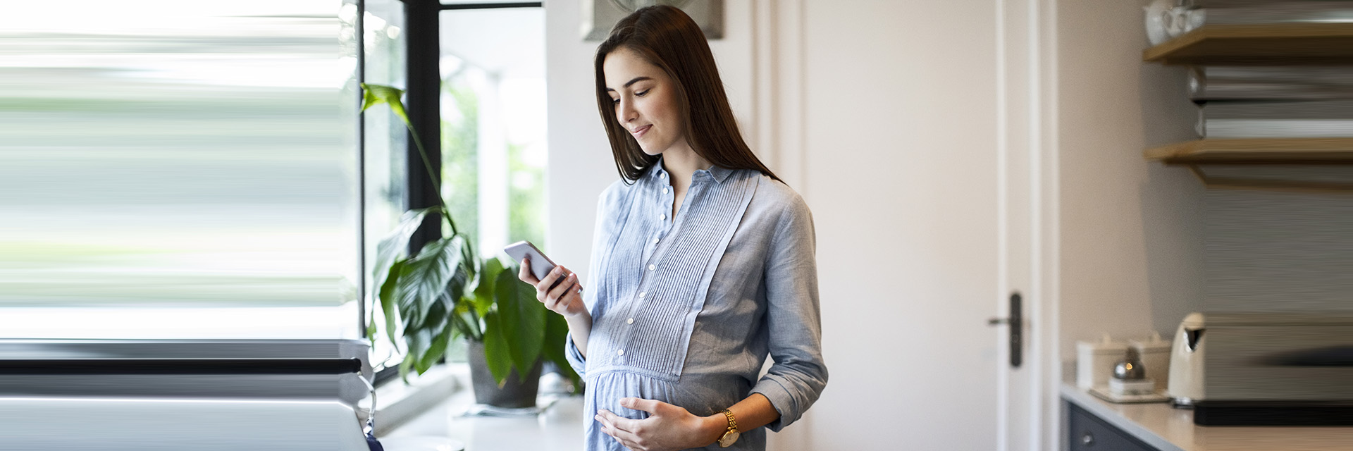 Pregnant Woman Looking at Cell Phone