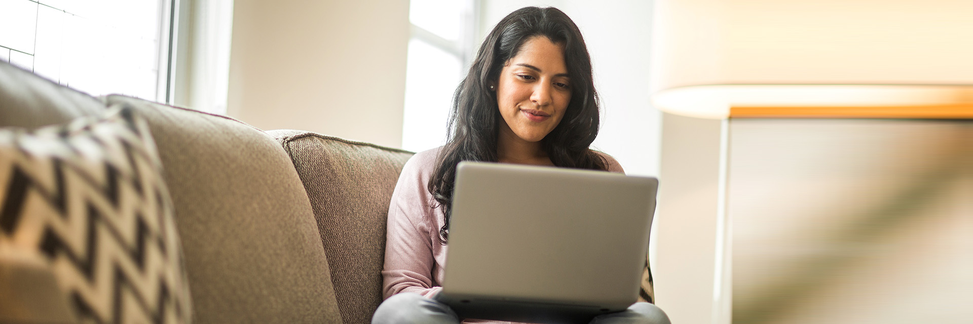 Woman on couch using laptop