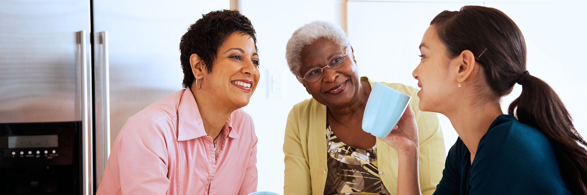 Women drinking coffee in kitchen