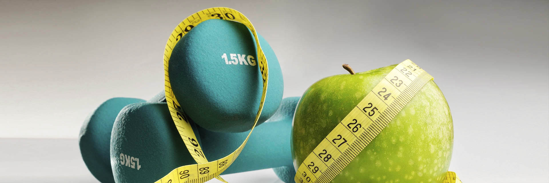 Apple, measuring tape, and dumbbells weights