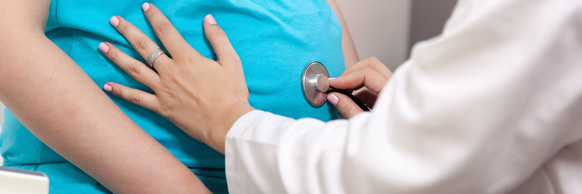 Gynecologist Checking Pregnant Woman's Belly With Stethoscope