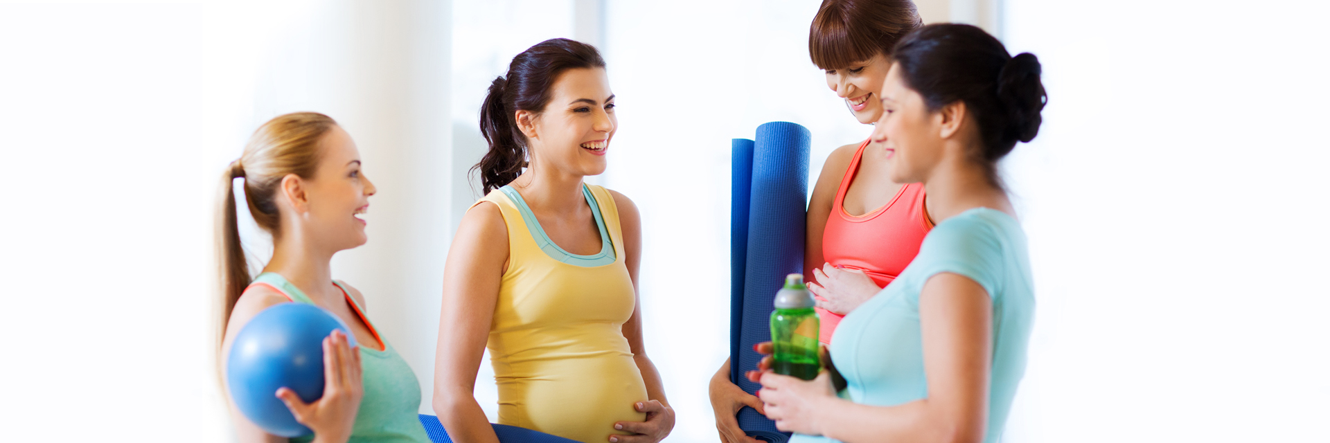 Pregnant women with yoga mats in class