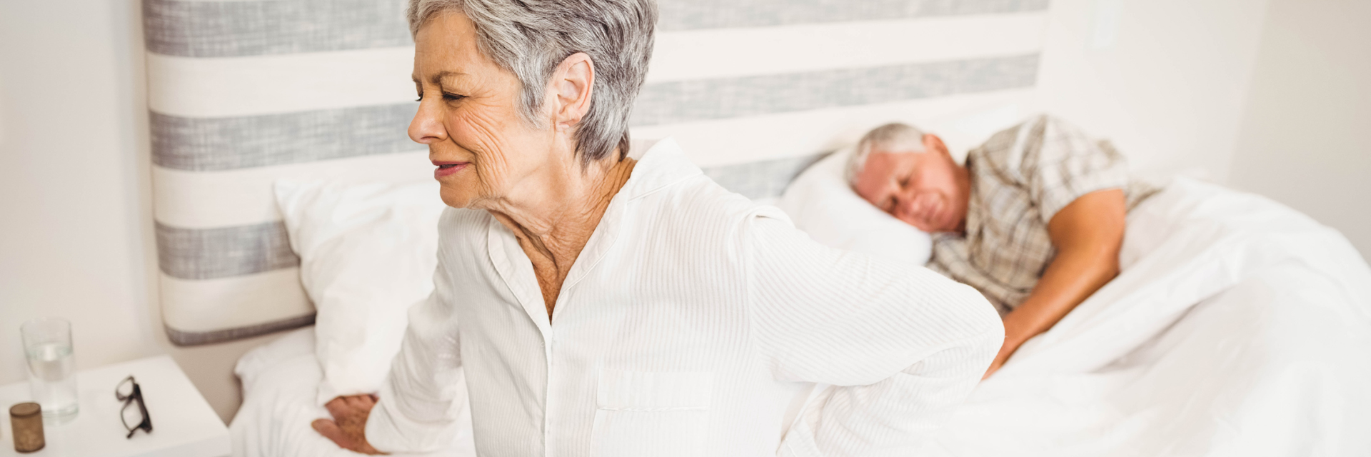 Woman getting out of bed with back pain