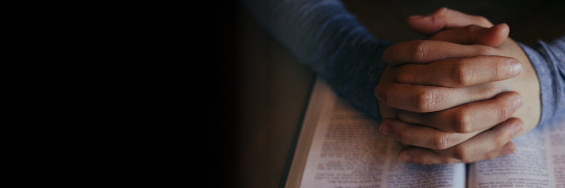 Interlaced Hands Over a Religious Book