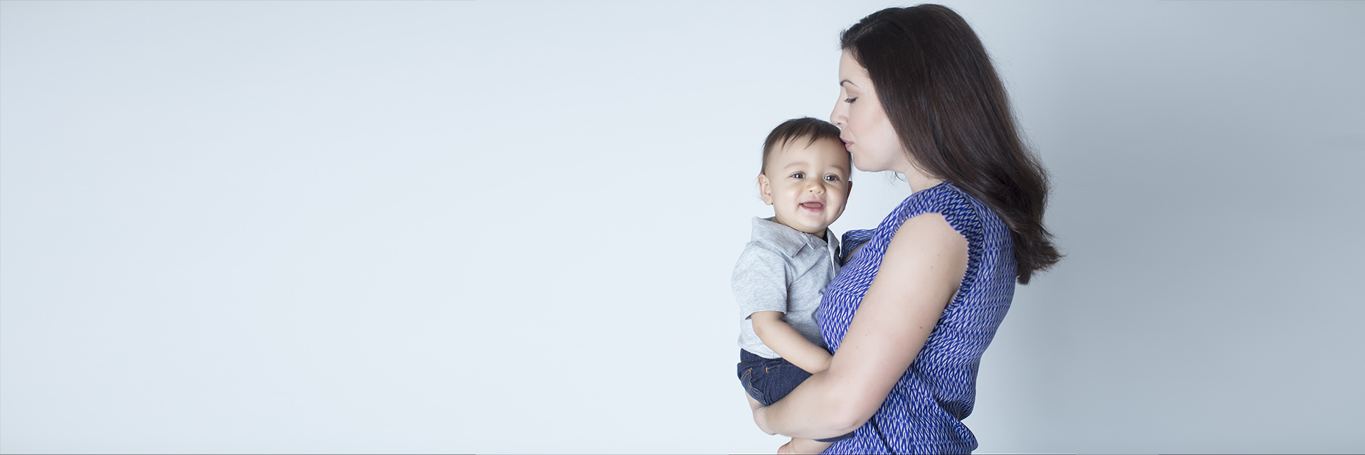 Young Mom Holding Toddler Boy in Her Arms
