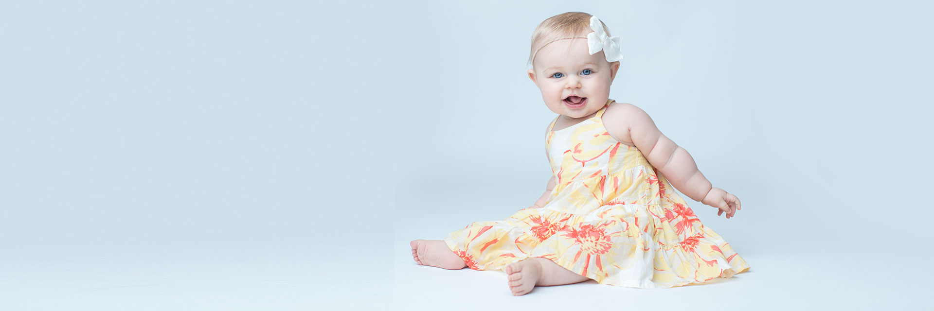 Toddler girl sitting in yellow dress