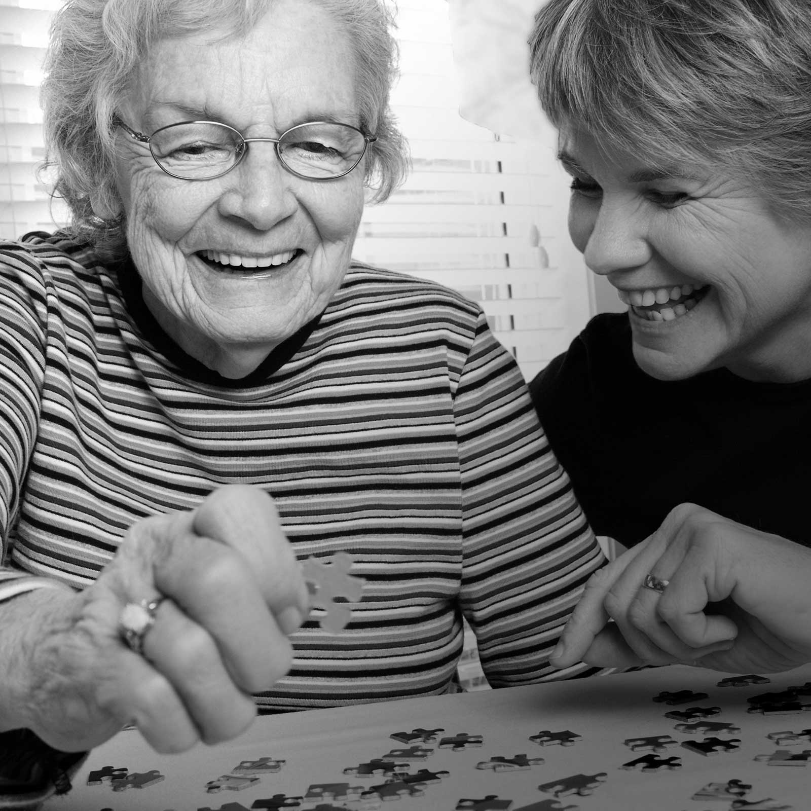 Mature woman and daughter working a puzzle