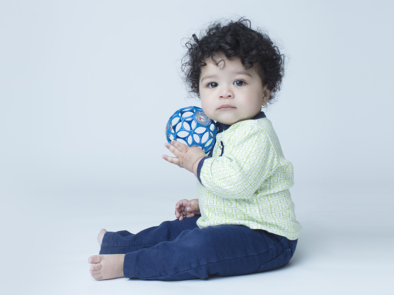 Baby Boy Sitting on Floor Dreessed in Blue