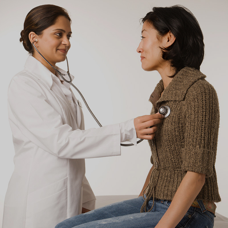 Doctor using stethoscope on patient