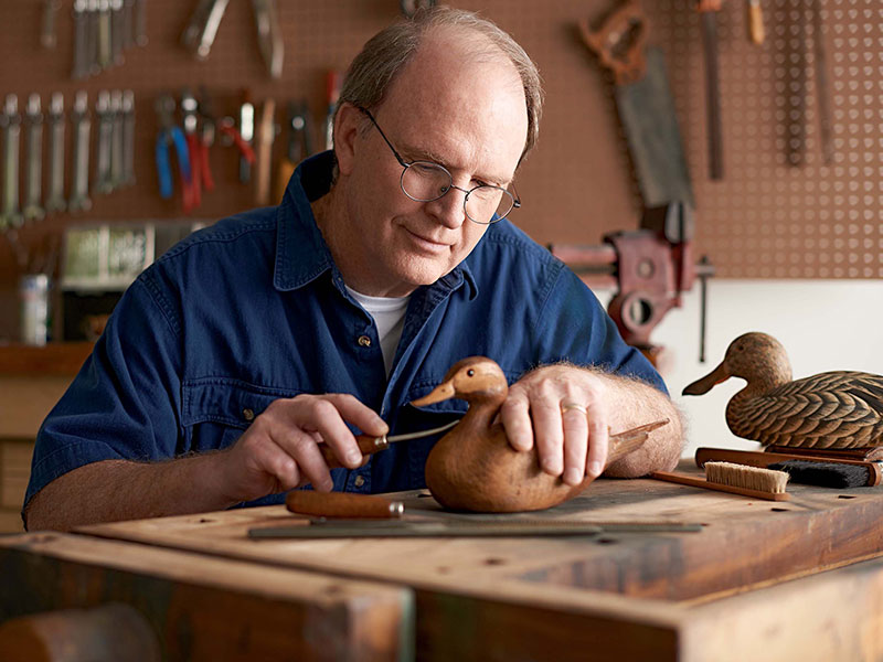 Man carving wooden duck