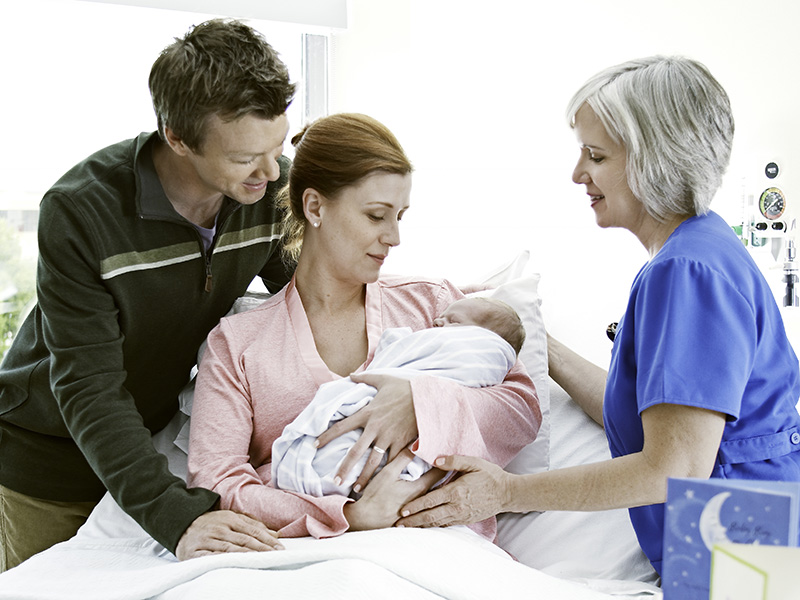 Couple Holding a Newborn with a Provider