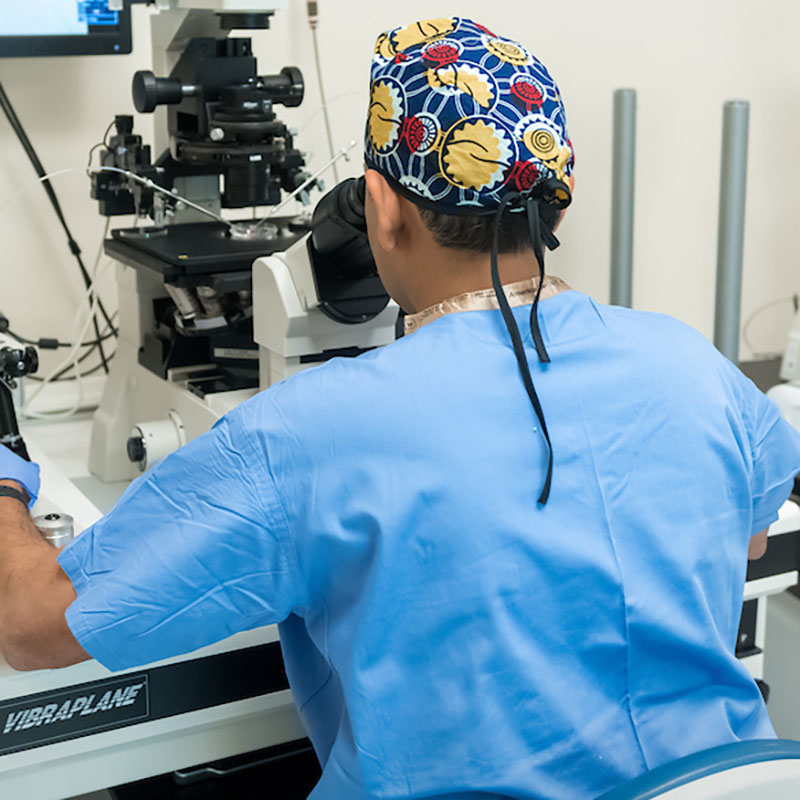 Male Researcher Looking Through Microscope