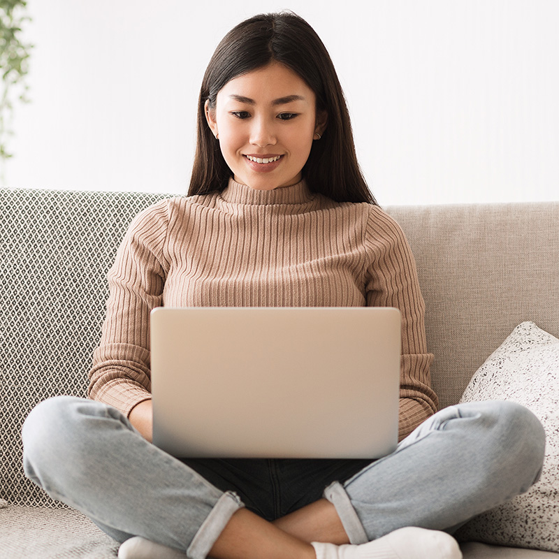 Woman on sofa using laptop