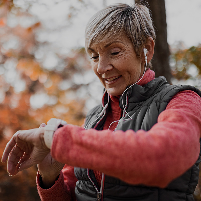 Woman with earbuds checking watch