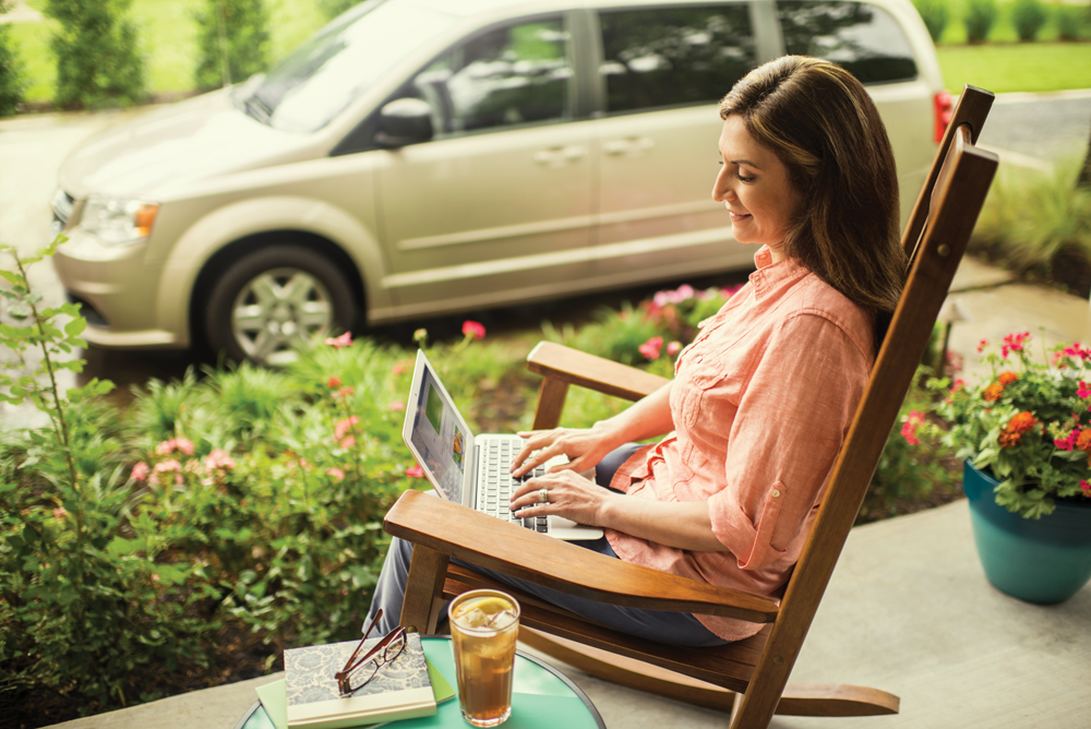 Woman on laptop in rocking chair outside