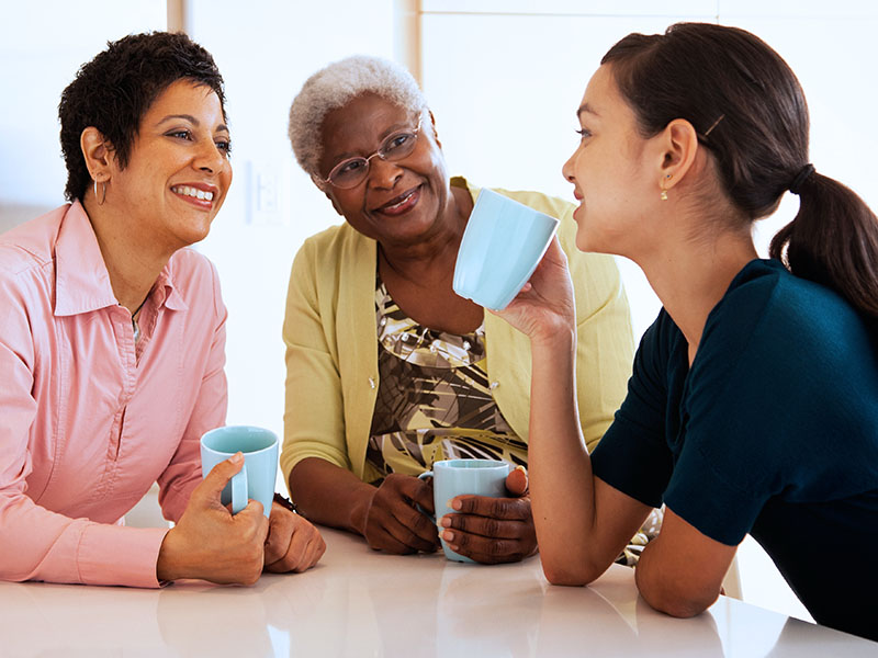 Women Drinking Coffee in Kitchen