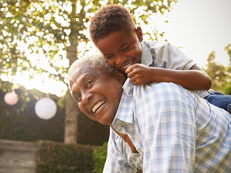 Older man playing with young boy outdoors