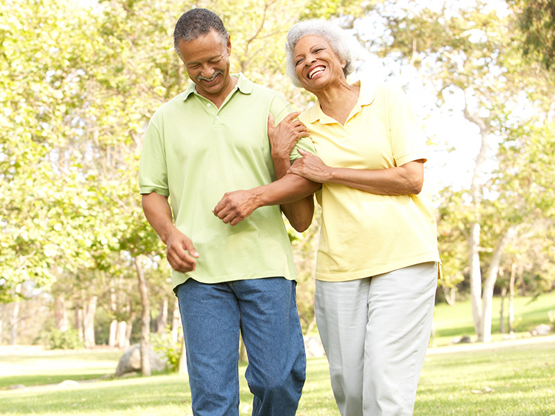 Couple in park holding arms