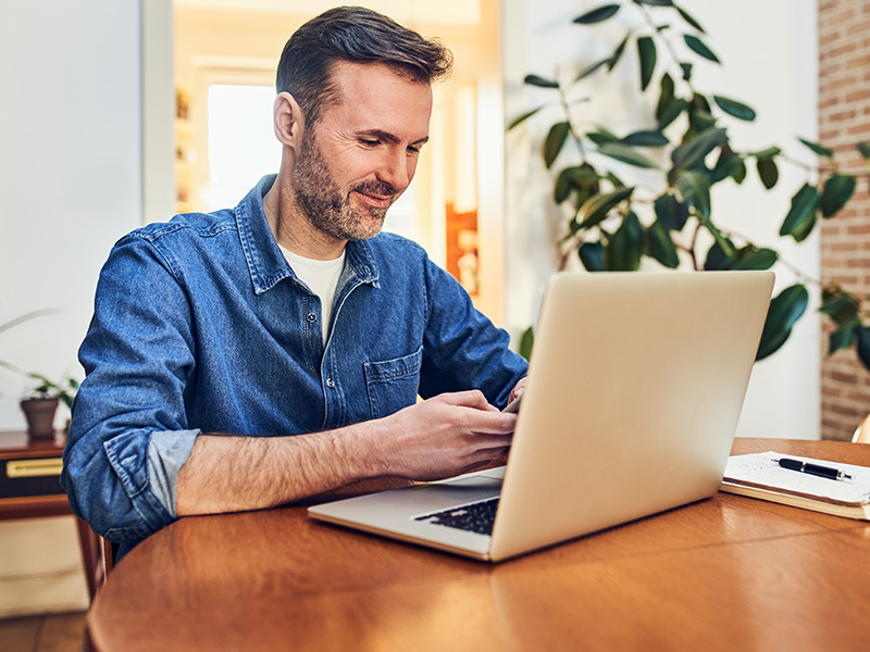 Man using phone and laptop