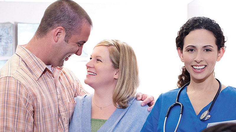 Happy couple smiling with nurse