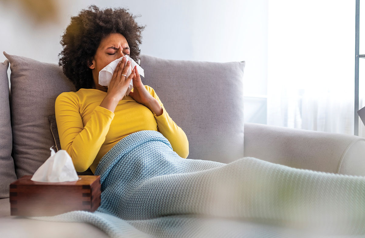 Woman sneezing on sofa