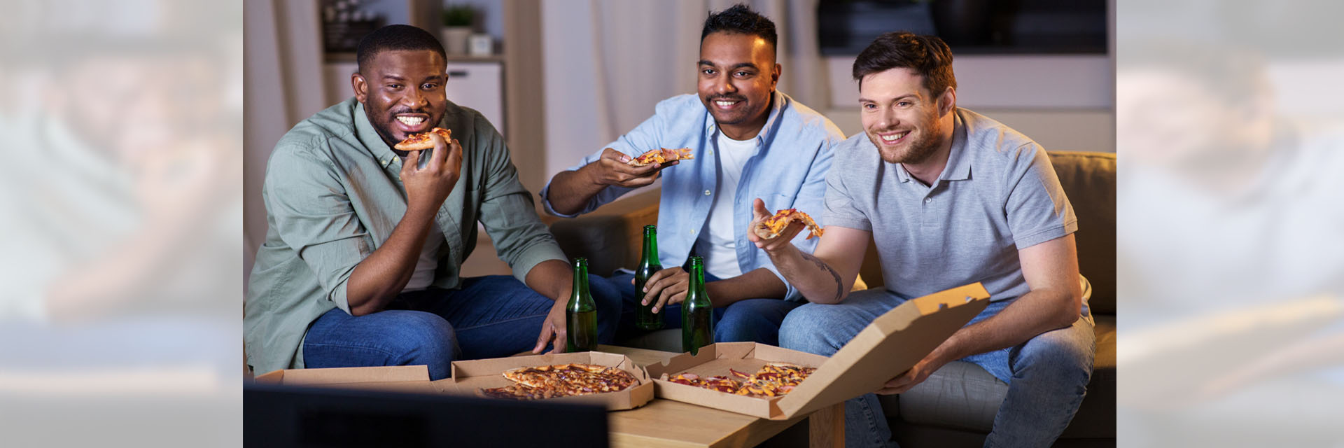 3 men eating pizza at table
