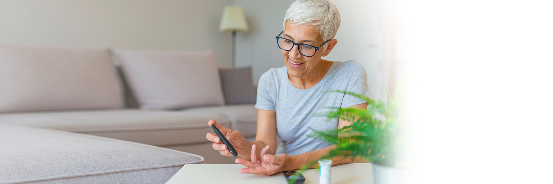 Woman at table doing finger stick