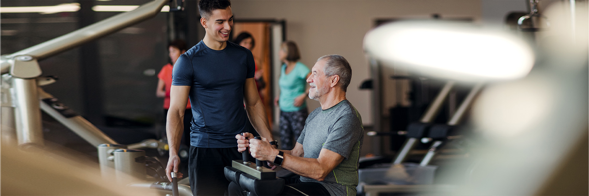 Mature man at the gym using weight machines