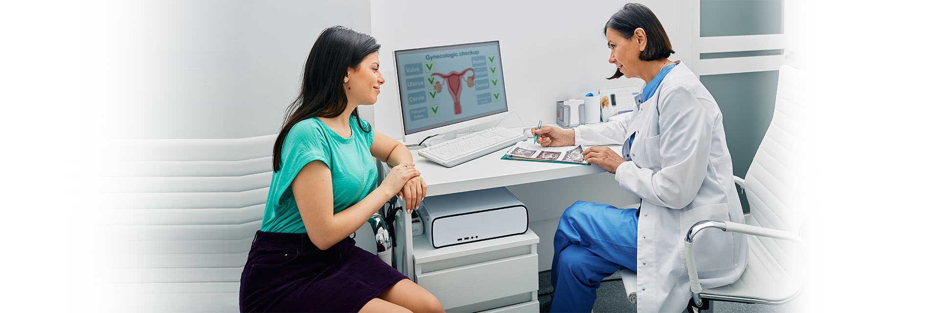 Female provider and patient in front of gynecology screen