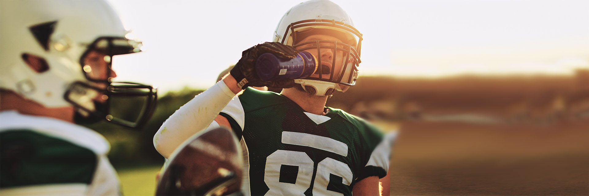 Young football player drinking water