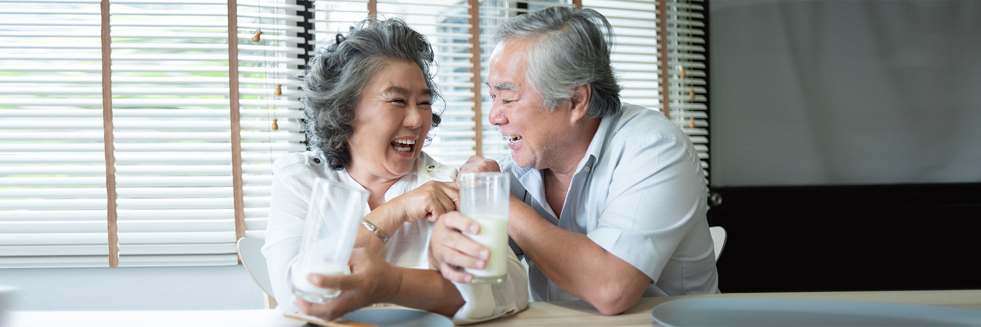Mature couple having a glass of milk at a table