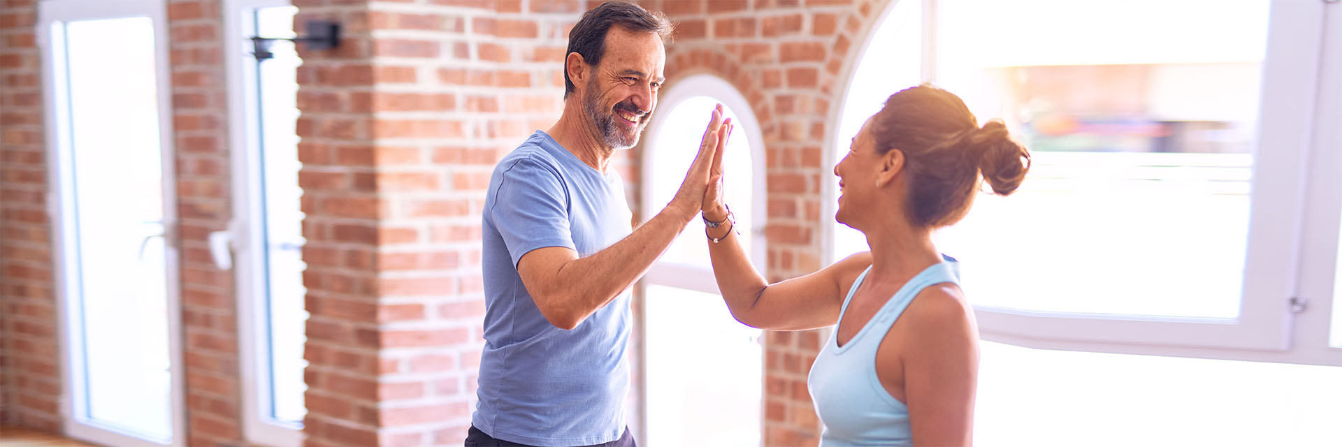 Mature couple high fiving at the gym