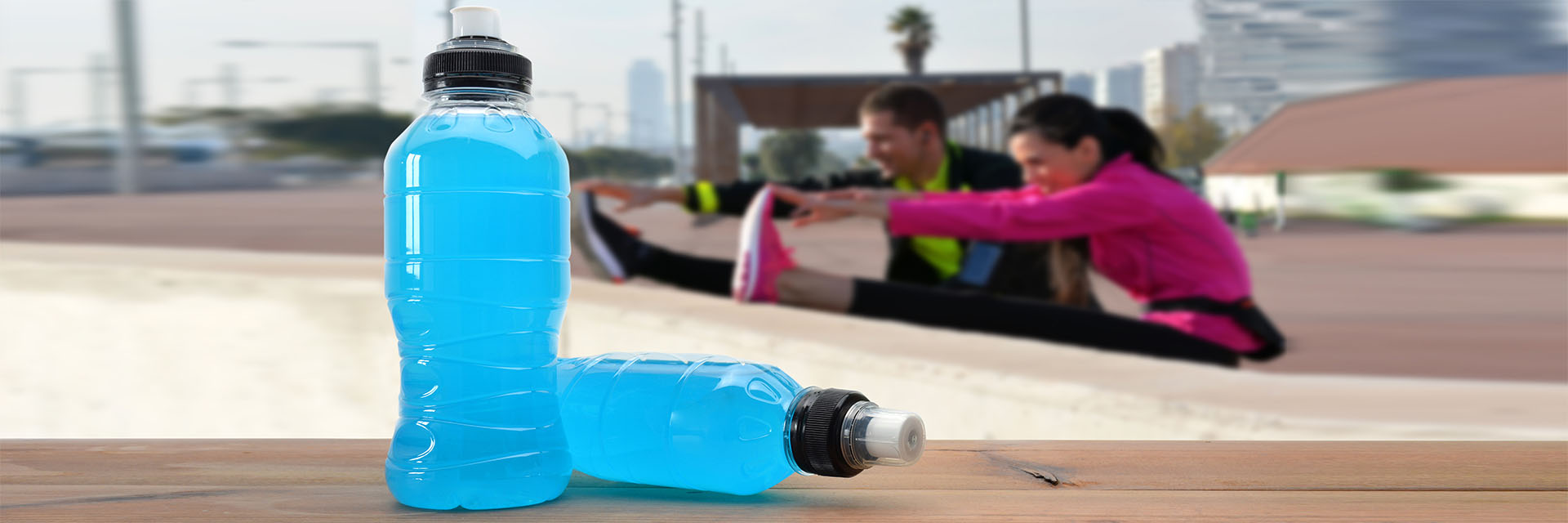 Couple stretching in background with bottles in foreground