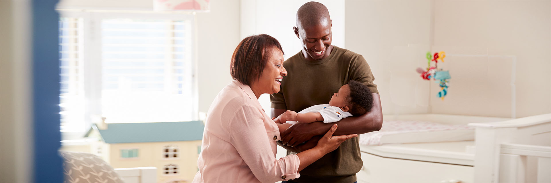 Dad and grandmother holding an infant 