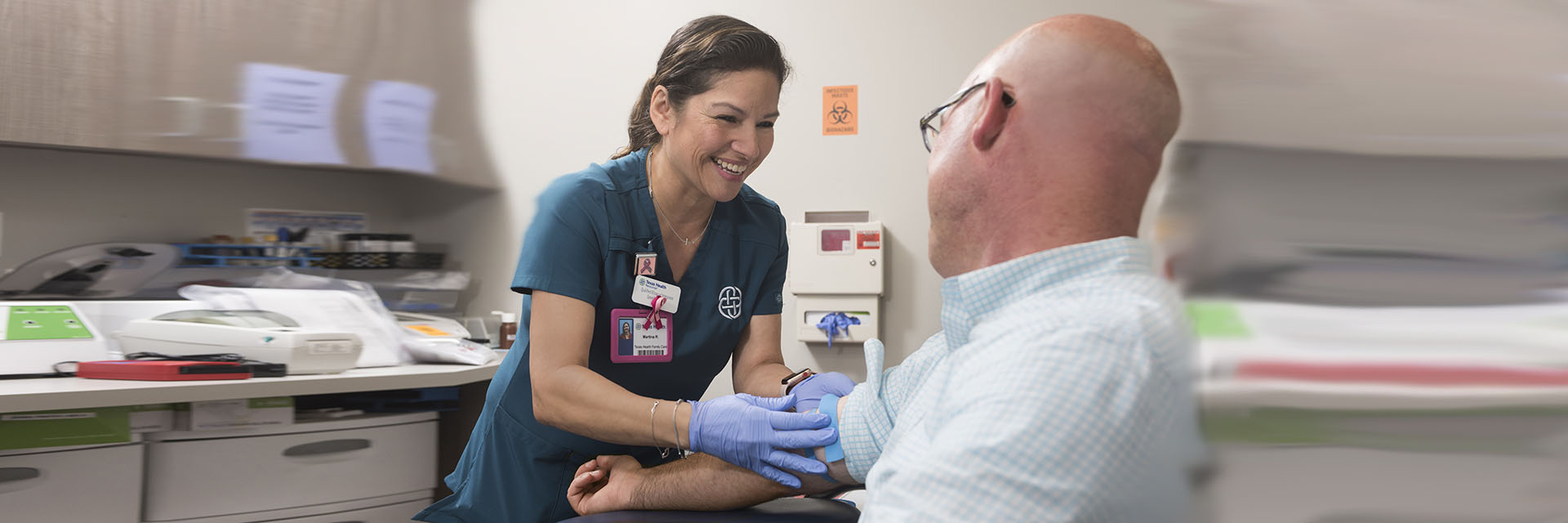 Nurse drawing blood from man