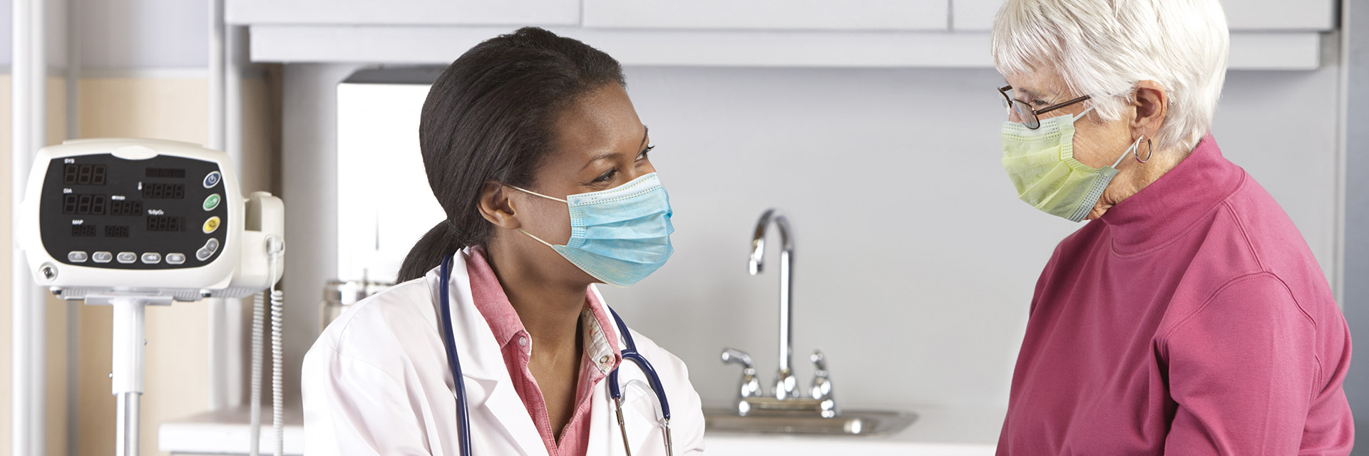 Masked female patient talking to provider