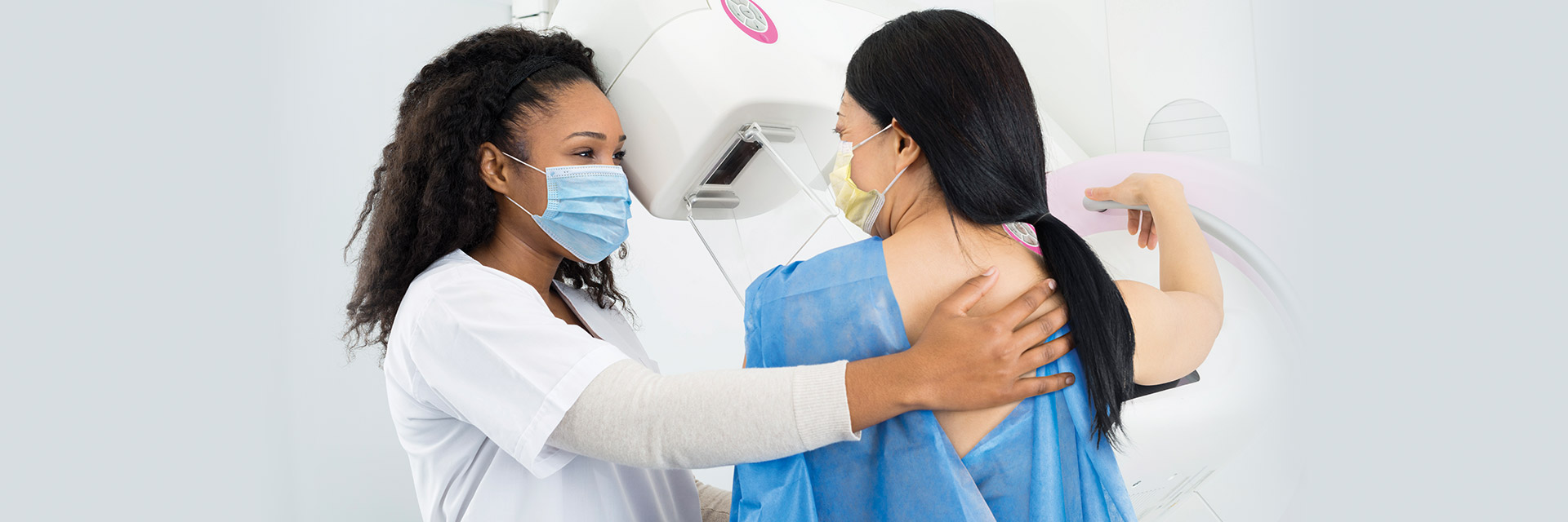 Masked female patient having a mammogram