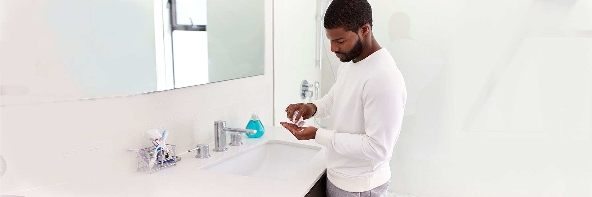 Man in bathroom in front of medicine cabinet