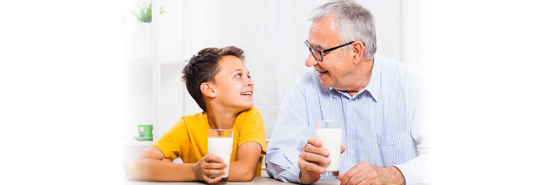Man and grandson holding glass of milk