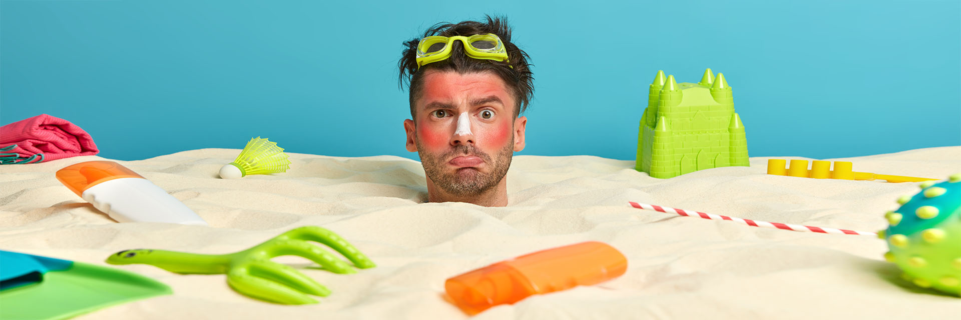 A man with sunscreen buried in sand