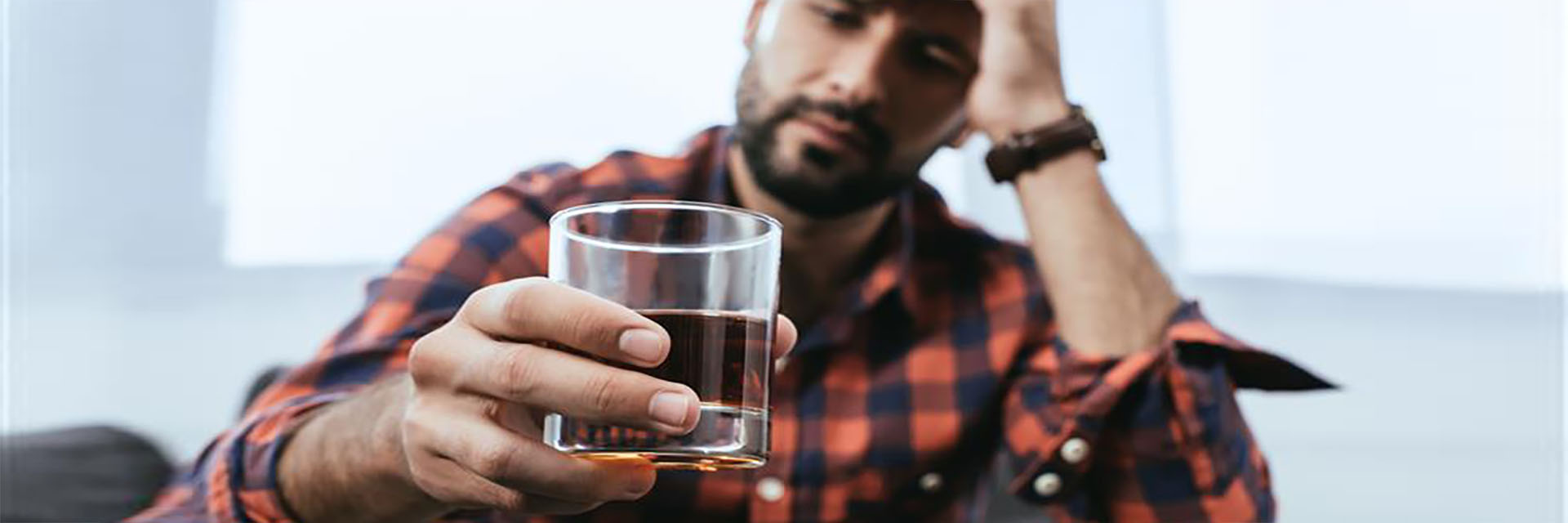 Sad man holding drink in ihands