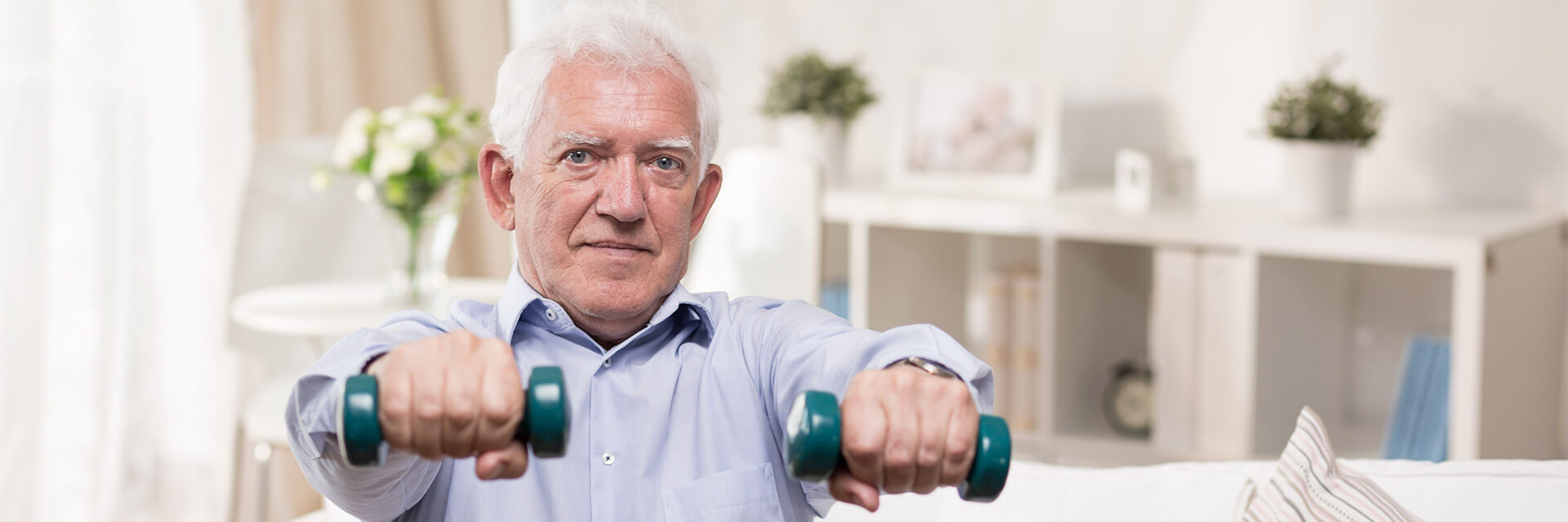 Mature man in dress shirt holding weights