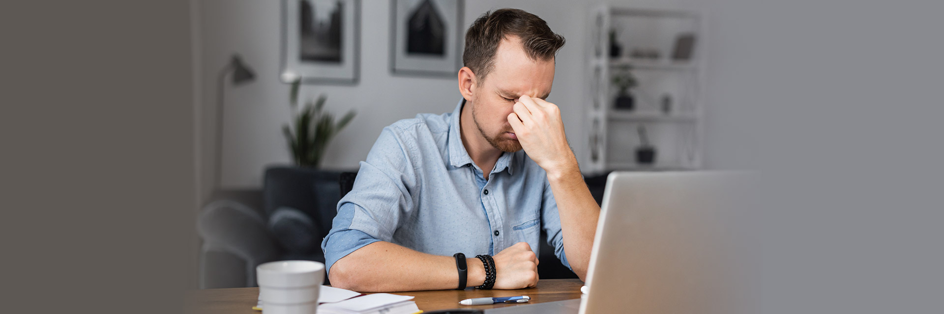 Man in front of computer rubbing his face