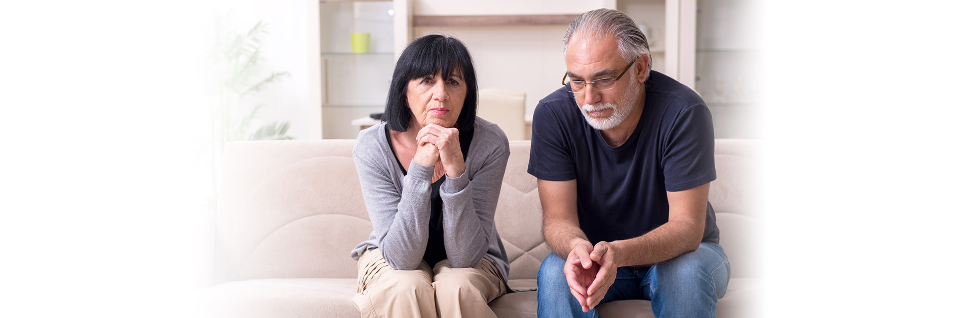 Worried couple sitting on sofa