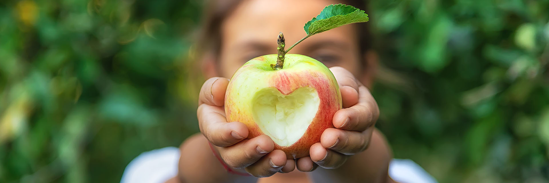 Person holding an apple outdoors