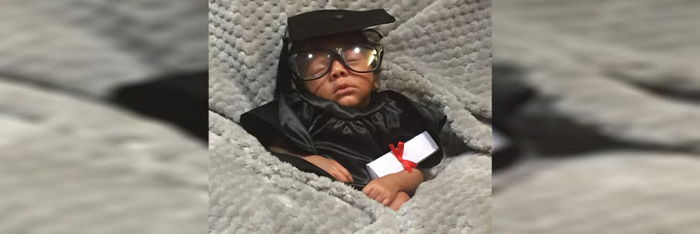Infant bot in the N I C U  dressed in cap and gown