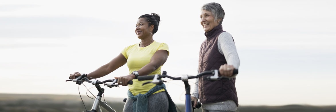 Women smiling while holding their bikes